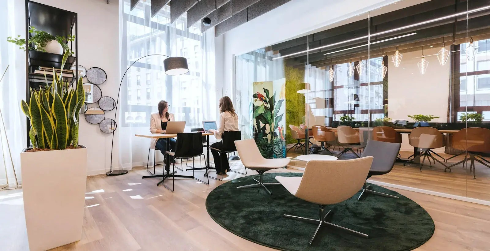 Two people working together at a table in a bright open-plan office